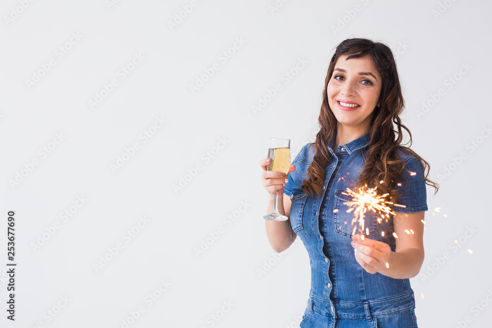People, celebration and holiday concept - Lovely woman with sparkler and glass of champagne over white background with copy space People, celebration and holiday concept - Lovely woman with sparkler and glass of champagne over white background with copy space