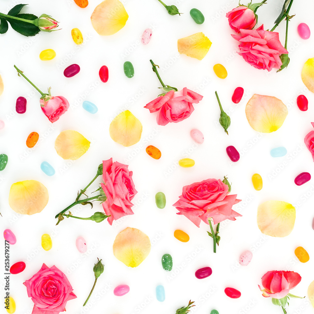 Roses flowers and petals with bright sugar candy's on white background. Flat lay, top view. Roses flowers and petals with bright sugar candy's on white background. Flat lay, top view.