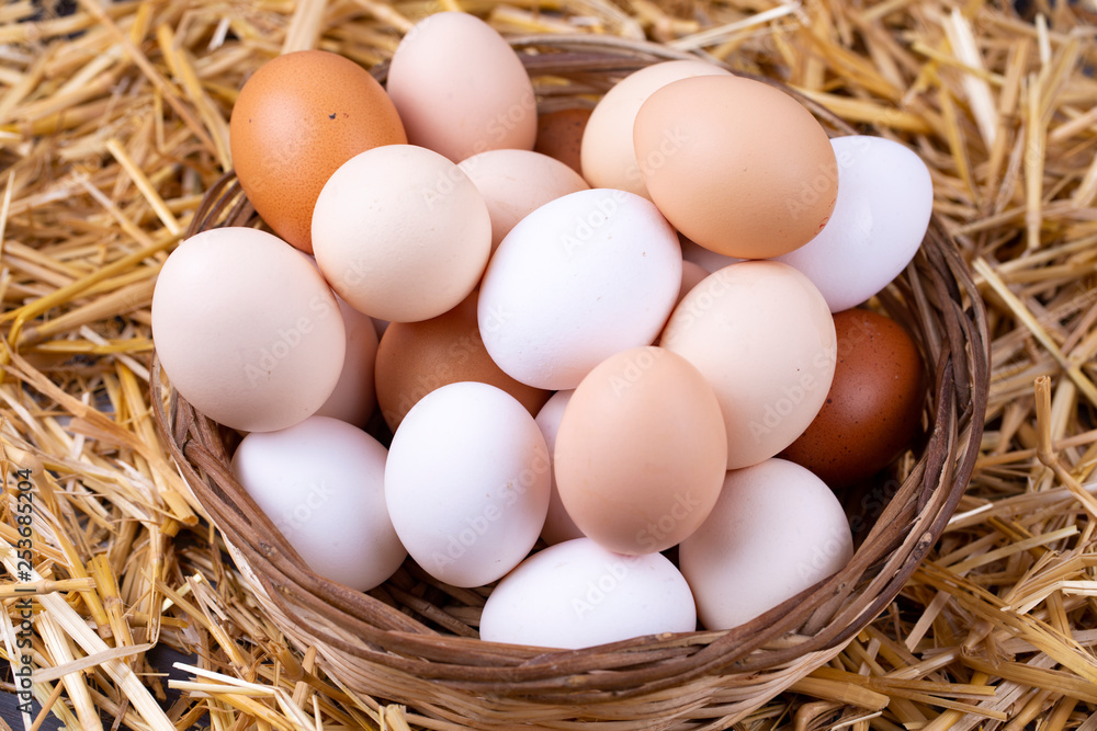 Raw eggs in dry straw. Food concept photo.