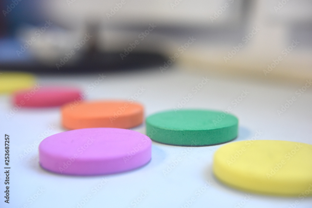 Spongy round flat items of different colours on the white background indoor Spongy round flat items of different colours on the white background indoor