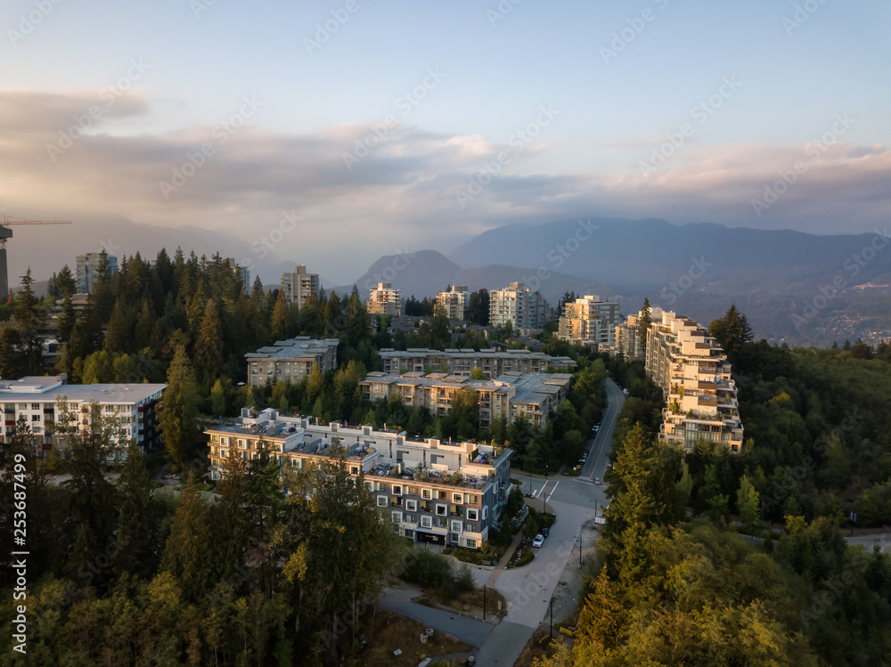 Aerial view of residential buildings on top of Burnaby Mountain during a vibrant sunset. Taken in Greater Vancouver, BC, Canada.