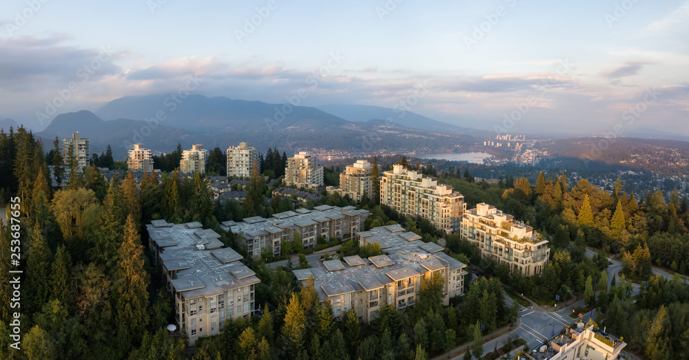 Aerial view of residential buildings on top of Burnaby Mountain during a vibrant sunset. Taken in Greater Vancouver, BC, Canada.