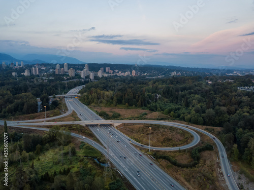 Aerial view of a highway entrance and exit in the modern city during a vibrant summer sunset. Taken in Burnaby, Greater Vancouver, BC, Canada.