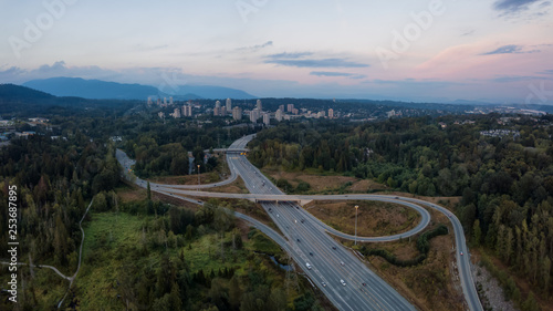 Aerial panoramic view of a highway entrance and exit in the modern city during a vibrant summer sunset. Taken in Burnaby, Greater Vancouver, BC, Canada.
