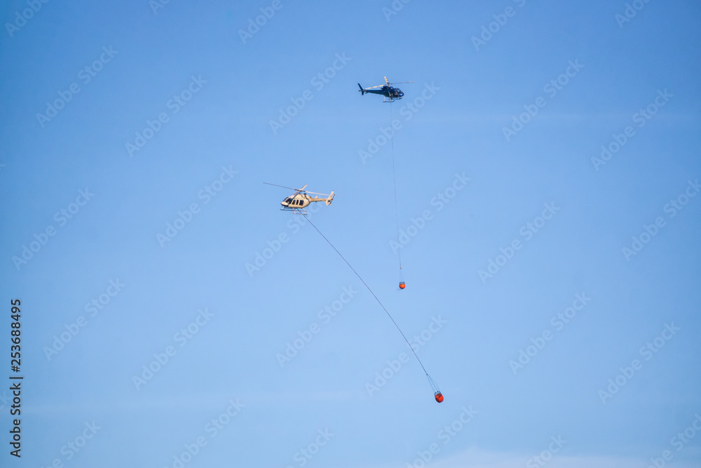 Helicopter fighting BC forest fires during a hot sunny summer day. Taken near Port Alice, Northern Vancouver Island, British Columbia, Canada. Helicopter fighting BC forest fires during a hot sunny summer day. Taken near Port Alice, Northern Vancouver Island, British Columbia, Canada.