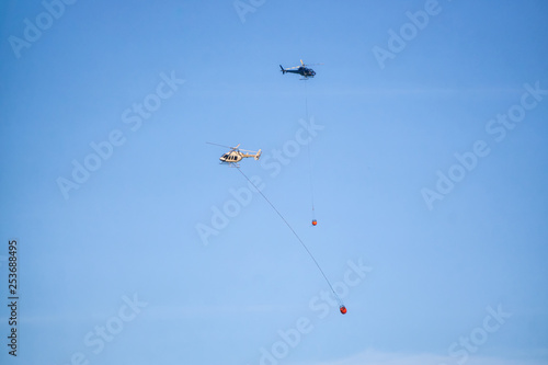 Helicopter fighting BC forest fires during a hot sunny summer day. Taken near Port Alice, Northern Vancouver Island, British Columbia, Canada.