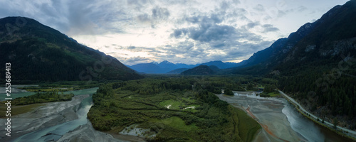 Aerial panoramic view of the river in the valley in the beautiful Canadian Mountain Landscape during a cloudy sunset. Taken near Pemberton, British Columbia, Canada.