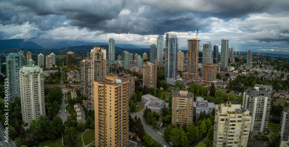 Fototapeta premium Aerial Panoramic view of residential homes in a modern city during a vibrant summer cloudy day. Taken in Burnaby, Vancouver, BC, Canada.