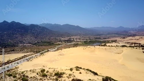 fantastic bird eye flight above deserted landscape with modern empty highway to dark hills under clear blue sky