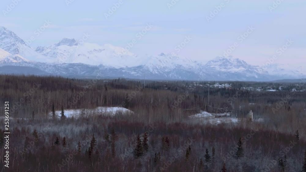 Anchorage, pan over forest in winter with snow capped mountains in Alaska. Anchorage, pan over forest in winter with snow capped mountains in Alaska.