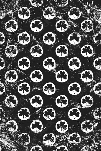 Grunge pattern with stamp signs of shamrocks. Vertical black and white backdrop.