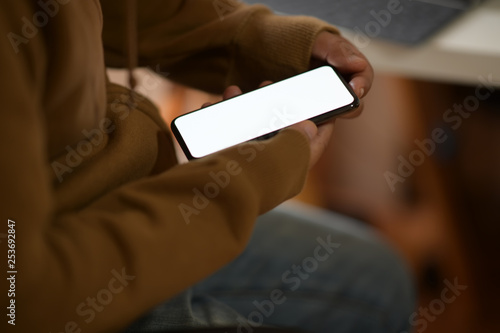 Male hand with a black mobile phone with white blank screen
