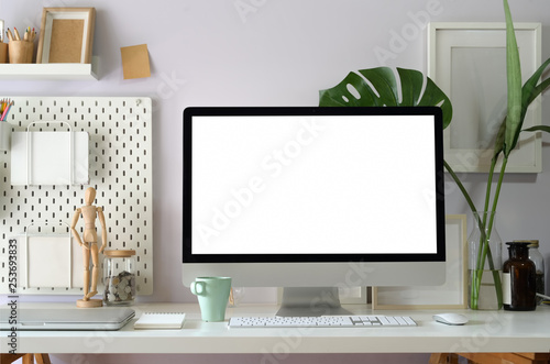 Mock up computer on loft workspace table showing blank white screen