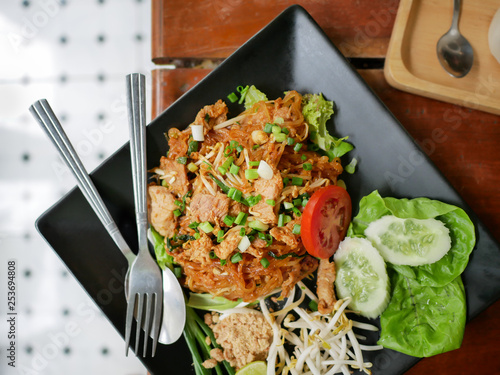 Closeup of Phadthai, Favorite popular thai noodle food with vegetables side dishes on black plate