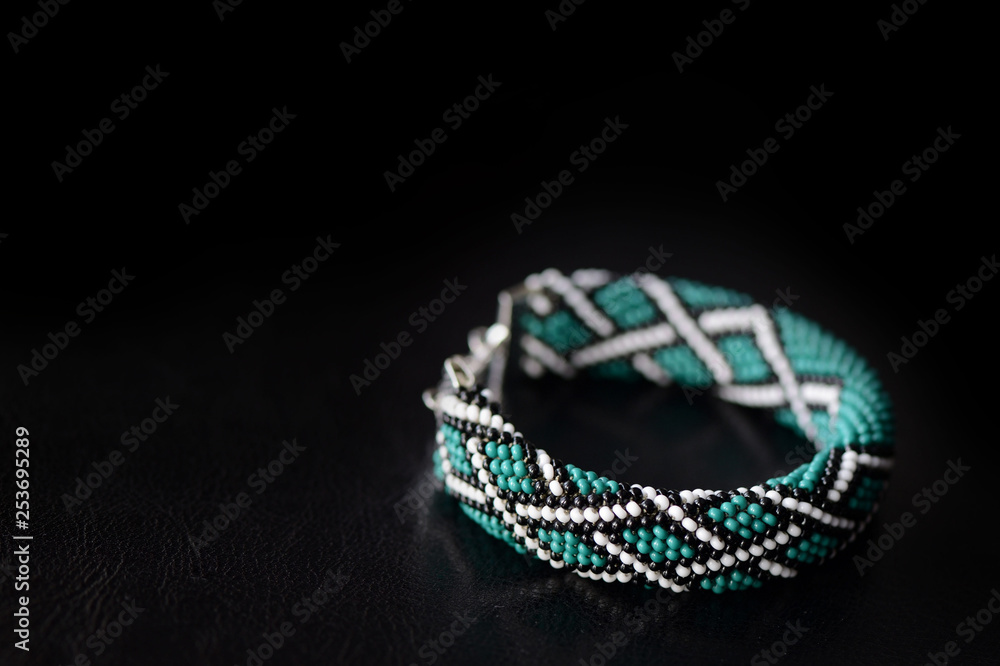 Celtic print emerald color bracelet on a dark background close up Celtic print emerald color bracelet on a dark background close up