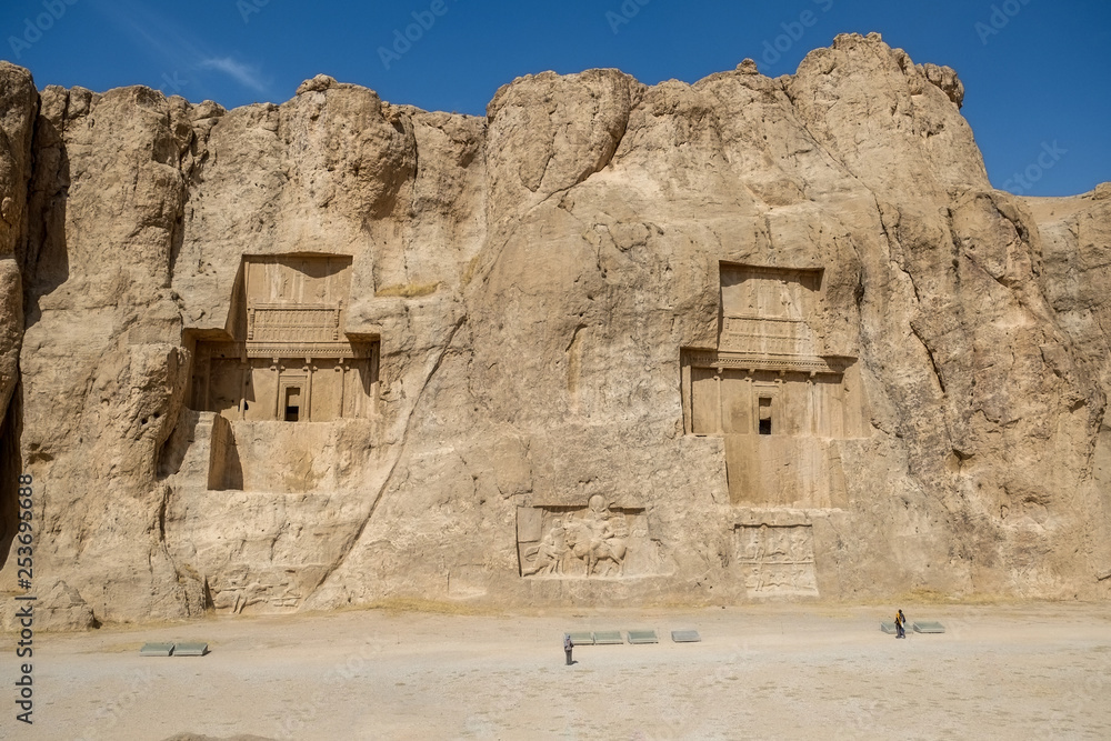 Landscape famous landmark of the ancient Naqsh-e Rustam shows large tombs cut high into the cliff face. Fars Province, Iran.