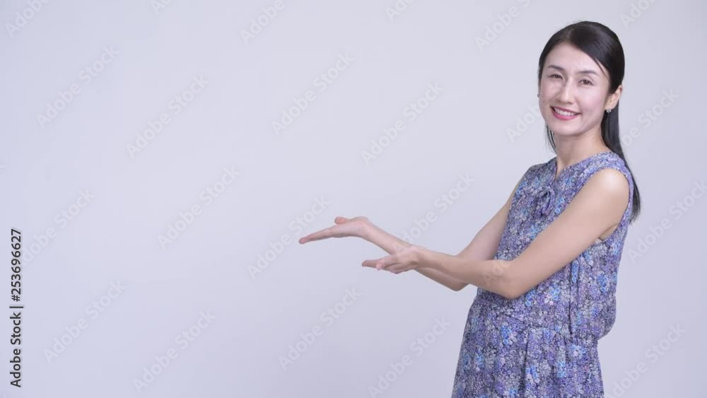 Happy pregnant Asian woman showing something Happy pregnant Asian woman showing something