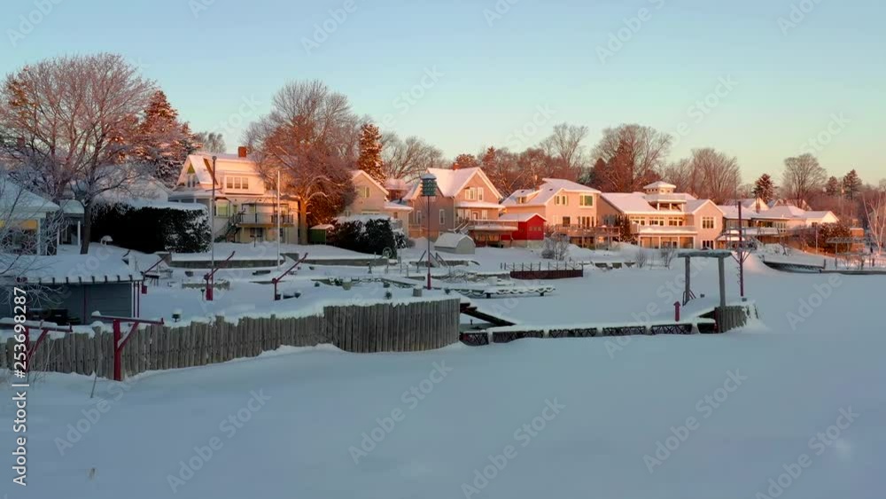 Peaceful waterfront homes under fresh snow, sunrise in Winter. Peaceful waterfront homes under fresh snow, sunrise in Winter.