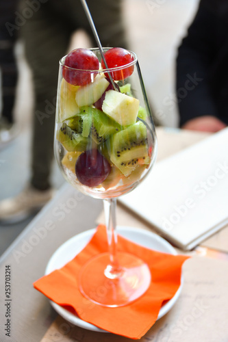 fruit salad of kiwi, banana, Apple and grapes. salad in a large glass. selective focus