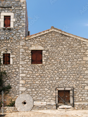 Wallpaper Mural Traditional stone house with wooden windows and decorative millstone in a Greek village in Mani. Torontodigital.ca