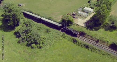 Aerial pullback shot tracking a Steam Locomotive with carriages. photo