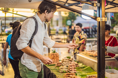 Photography Young man tourist on Walking street Asian food market