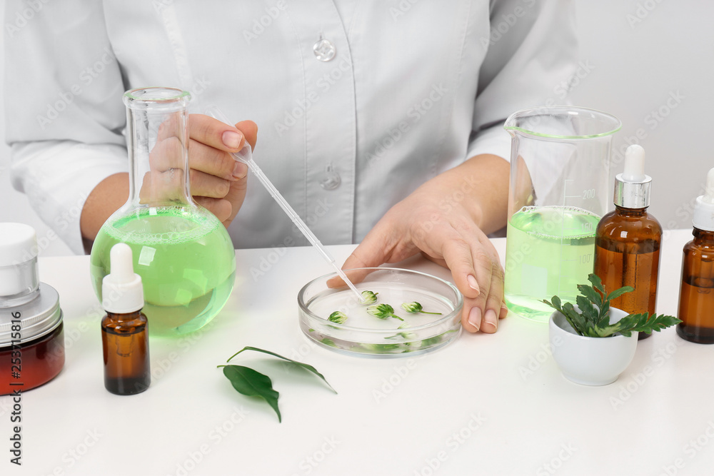 Female dermatologist creating skin care product at table, closeup Female dermatologist creating skin care product at table, closeup
