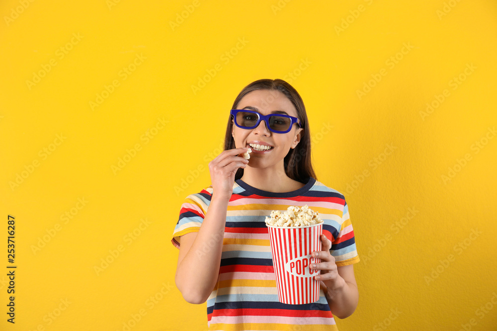 Young woman with 3D glasses and tasty popcorn on color background Young woman with 3D glasses and tasty popcorn on color background