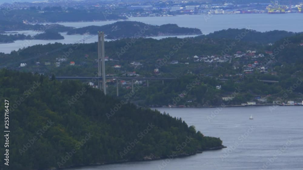 Beautiful high, wide view of the waterways and fjords surrounding Bergen, Norway. Sunlight reflects on the surface of the calm sea. A large bridge between islands with cars driving across. Beautiful high, wide view of the waterways and fjords surrounding Bergen, Norway. Sunlight reflects on the surface of the calm sea. A large bridge between islands with cars driving across.