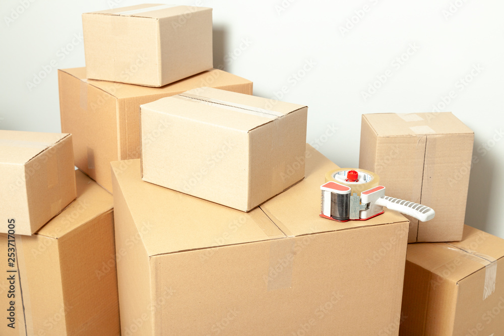 Day moving. Cardboard boxes on gray wall background Day moving. Cardboard boxes on gray wall background