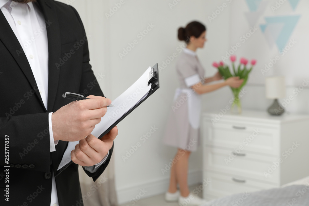 Housekeeping manager checking maid work in hotel room, closeup Housekeeping manager checking maid work in hotel room, closeup