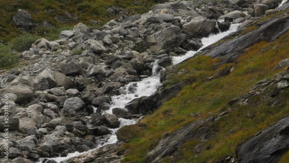 Cascading mountain creek, fast flowing rapids over rocks and boulders in Norwegian mountains, vicinity of Trolls ladder, also Trollstigen, slow panning shot following the stream Cascading mountain creek, fast flowing rapids over rocks and boulders in Norwegian mountains, vicinity of Trolls ladder, also Trollstigen, slow panning shot following the stream