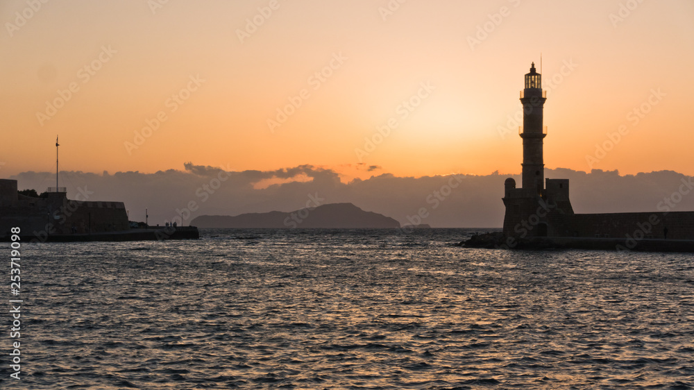 Lighthouse at sunset in the old Venetian harbor, city of Chania, Crete island, Greece