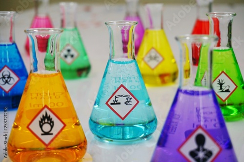 Wallpaper Mural Many of Erlenmeyer flask with colorful solution and Variety type of chemical hazard warning symbols labels