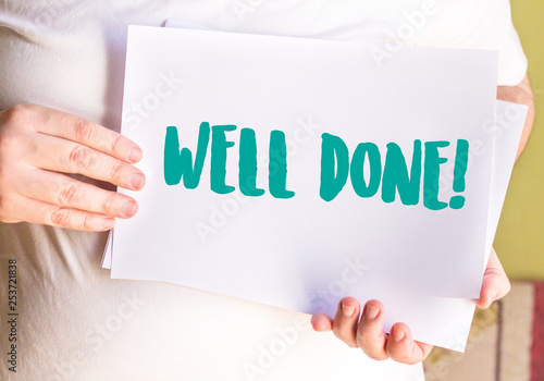 businessman holding the WELL DONE! written on white paper photo