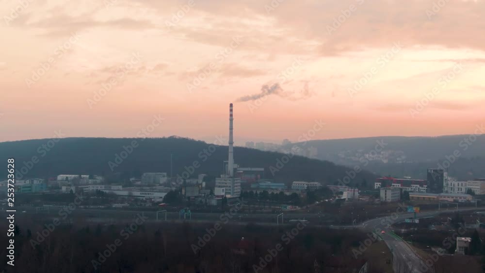 Polluting Factory Chimney in City during Sunset and Golden Hour. Pollution of the environment: a pipe with smoke. Aerial view with drone Polluting Factory Chimney in City during Sunset and Golden Hour. Pollution of the environment: a pipe with smoke. Aerial view with drone
