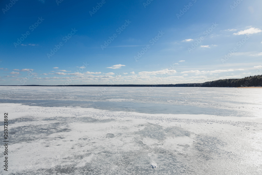 Winter landscape with frozen lake in clear weather