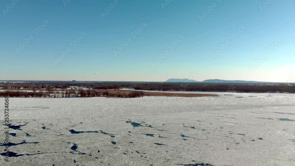Aerial view of frozen river with some ice melting and some standstill at the end of winter slow motion Aerial view of frozen river with some ice melting and some standstill at the end of winter slow motion