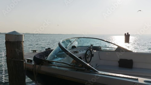 Wallpaper Mural Moored boat at rest in a relaxing, calm lake, with seagulls flying and mountains in the distance, in a winter, cold day. Torontodigital.ca