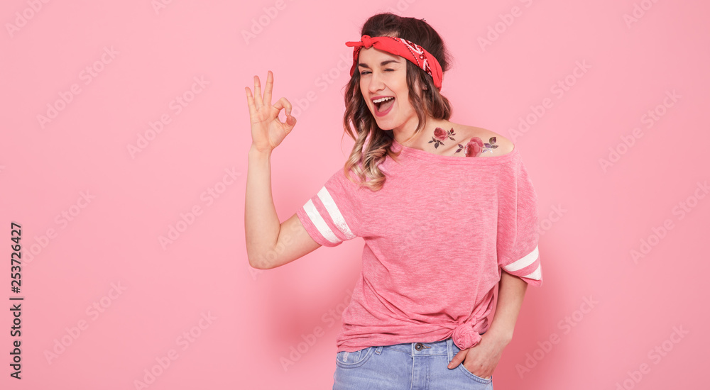 Portrait of a hipster girl with tattoo, isolated on pink background Portrait of a hipster girl with tattoo, isolated on pink background