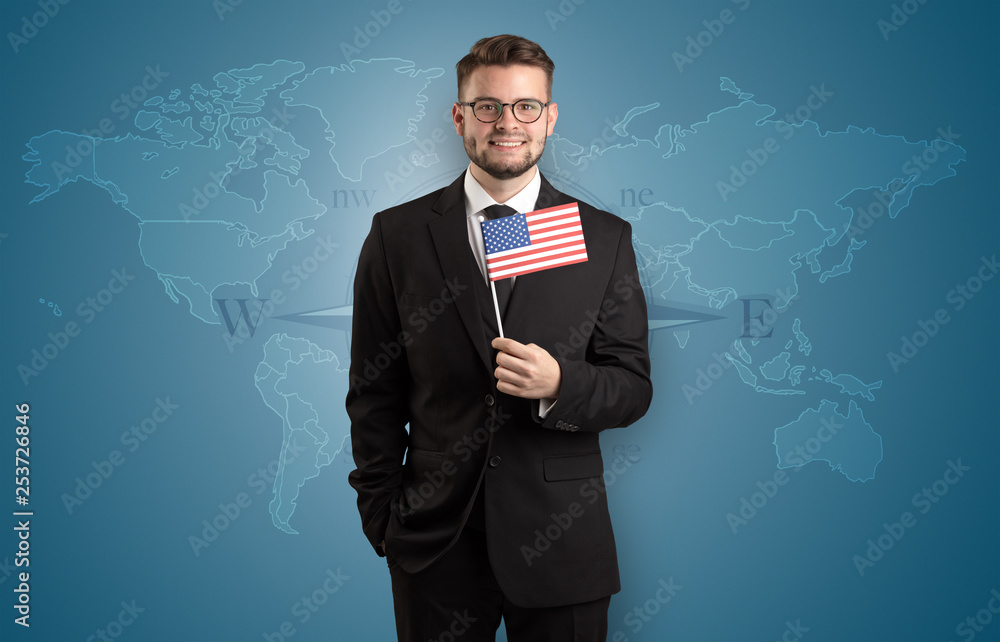 Cheerful businessman standing in front of a map with flag on his hand
Cheerful businessman standing in front of a map with flag on his hand
