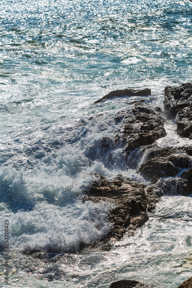 Obraz premium Mediterranean Sea water waves crashing on the shore rocks