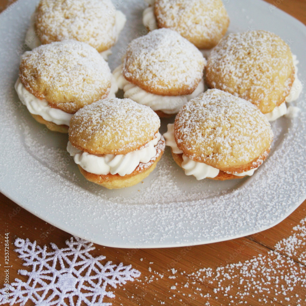 Traditional cinnammon whoopie pies filled with vanilla cream on a plate on wooden table Traditional cinnammon whoopie pies filled with vanilla cream on a plate on wooden table