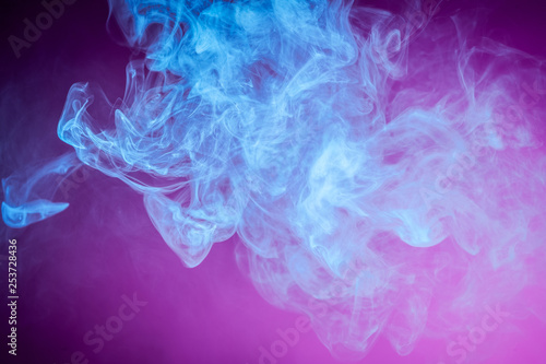 Colorful blue smoke on a pink isolated background. Background from the smoke of vape.
