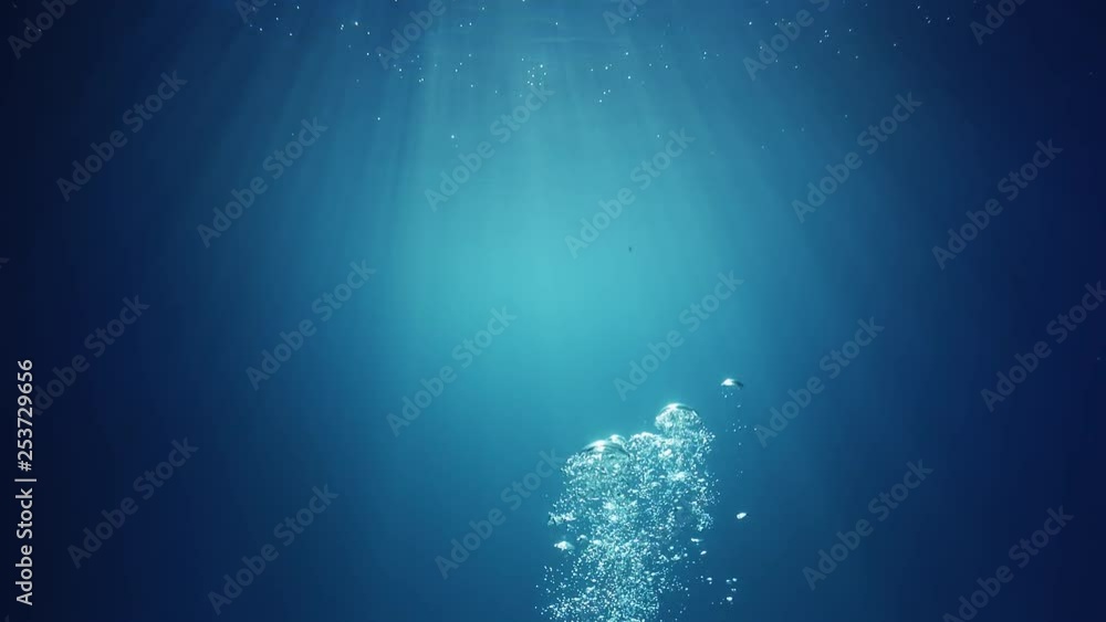 Underwater sunlight beams shining from above coming through the deep crystal clear blue water causing a beautiful water lighting reflections curtain with air bubbles rising up to the surface Underwater sunlight beams shining from above coming through the deep crystal clear blue water causing a beautiful water lighting reflections curtain with air bubbles rising up to the surface