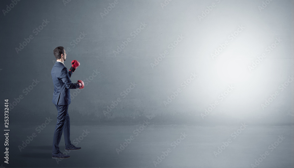 Businessman fighting with boxing gloves in an empty space
Businessman fighting with boxing gloves in an empty space
