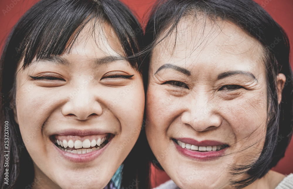Portrait of asian mother and daughter laughing in front of camera - Focus on left girl face Portrait of asian mother and daughter laughing in front of camera - Focus on left girl face