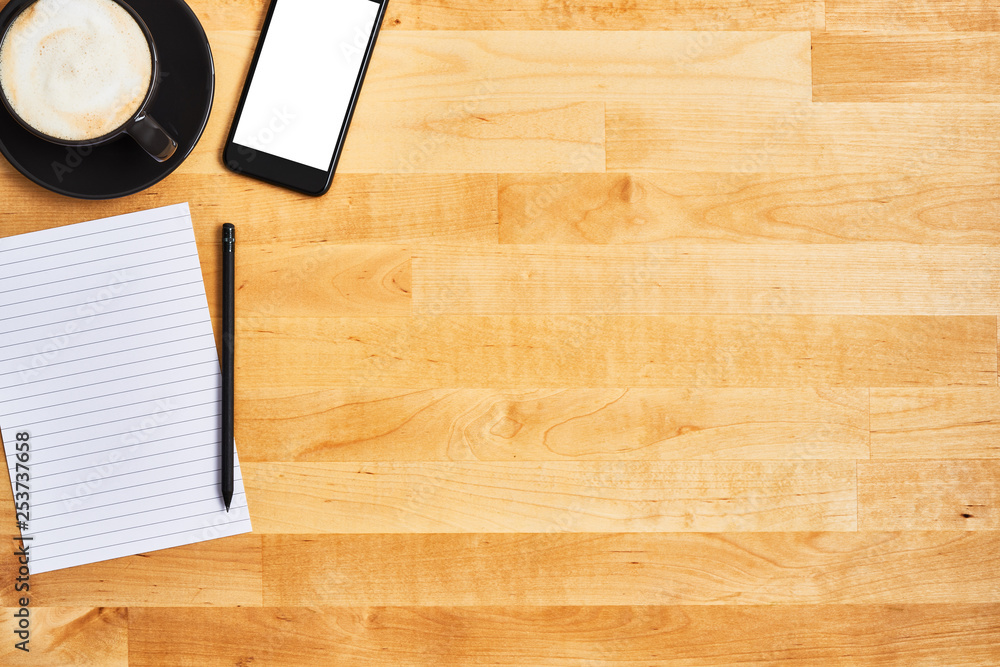 Cup of coffee or cappuccino with smartphone, an empty sheet of paper and pencil on yellow wooden table. Top view. Copy space for text. Cup of coffee or cappuccino with smartphone, an empty sheet of paper and pencil on yellow wooden table. Top view. Copy space for text.