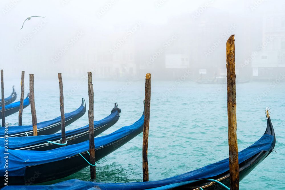 Traditional gondolas in Venice during a misty/foggy spring day, Italy.