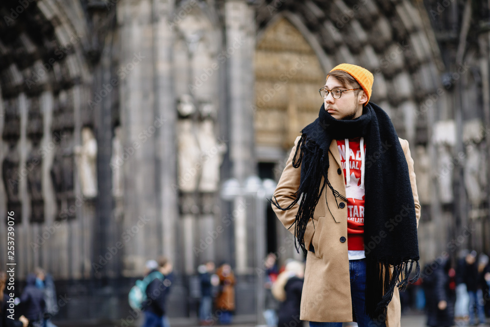 Casual style. Man stands against the sights. Cathedral Church of Saint Peter. Cologne Cathedral. Germany. Gothic architecture. 